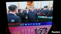 北京某购物中心的一块巨型屏幕播放新闻画面，显示中国领导人习近平在2月17日举行的一次民营企业座谈会上与阿里巴巴创始人马云握手的场景。（2025年2月17日）