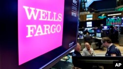 FILE - The Wells Fargo logo appears above a trading post on the floor of the New York Stock Exchange, Feb. 7, 2018. 