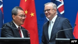 Perdana Menteri China Li Qiang dan Perdana Menteri Australia Anthony Albanese saling berjabat tangan setelah menyampaikan pidato pembukaan di gedung parlemen di Canberra, Australia, pada 17 Juni 2024. (Foto: Mick Tsikas/Pool/AFP)