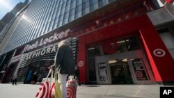 A woman carries Target shopping bags as she leaves the store, April 19, 2021 in New York.