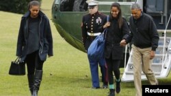 Presiden AS Barack Obama (kanan) bersama ibu negara Michelle Obama dan Malia Obama tiba kembali di Washington (4/1). 