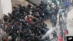 Police use pepper spray on protesters in Washington, Friday, Jan. 20, 2017, in a chaotic confrontation blocks from Donald Trump's inauguration as protesters registered their rage against the new president.