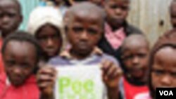 Children pose for a photo at the Bethel Outreach Children's Center in the Nairobi slum of Kibera as one boy holds up his Peepoo toilet, April 4, 2012. Toilet facilities are in poor condition or nonexistent in the slums, and safety concerns make using a to