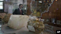 An Afghan journalist walks by an exhibit of minerals on the way to a news conference by the Afghan Minister of Mines in Kabul, Afghanistan, June 17, 2010