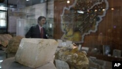 An Afghan journalist walks by an exhibit of minerals on the way to a news conference by the Afghan Minister of Mines in Kabul, Afghanistan, June 17, 2010