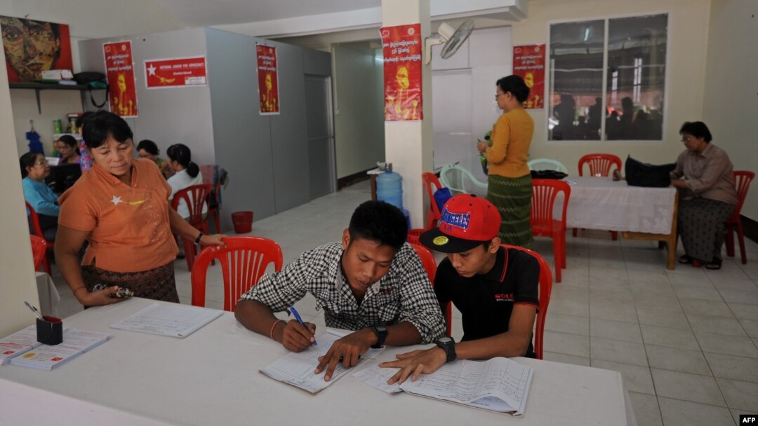 People signing amendment of the 2008 Constitution as members of National League for democracy collect signatures on a street in Yangon, July 16, 2014. 