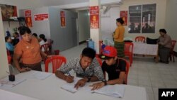 People signing amendment of the 2008 Constitution as members of National League for democracy collect signatures on a street in Yangon, July 16, 2014. 