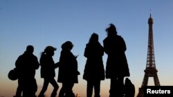 People stand at the Trocadero square near the Eiffel Tower in Paris, France, December 12, 2018. 