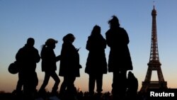 People stand at the Trocadero square near the Eiffel Tower in Paris, France, Dec. 12, 2018. 