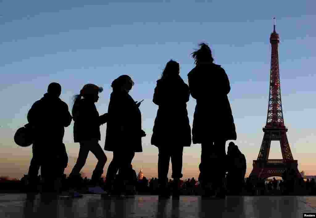 People stand at the Trocadero square near the Eiffel Tower in Paris, France, Dec. 12, 2018.