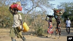 A Sudanese family from the war-torn Blue Nile state carry their belongings on their heads as they arrive at South Sudan's Doro refugee camp December 12, 2011.