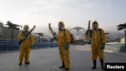 FILE - Municipal workers wait before spraying insecticide at Sambodrome in Rio de Janeiro, Brazil, Jan. 26, 2016.