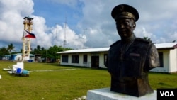 The main town hall of Kalayaan on Thitu Island with the bust of Tomas Cloma, the Filipino marine educator a nd entrepreneur who reportedly discovered the Kalayaan Group of Islands. The lone tower is also seen in the background. (D. Agnote for VOA)
