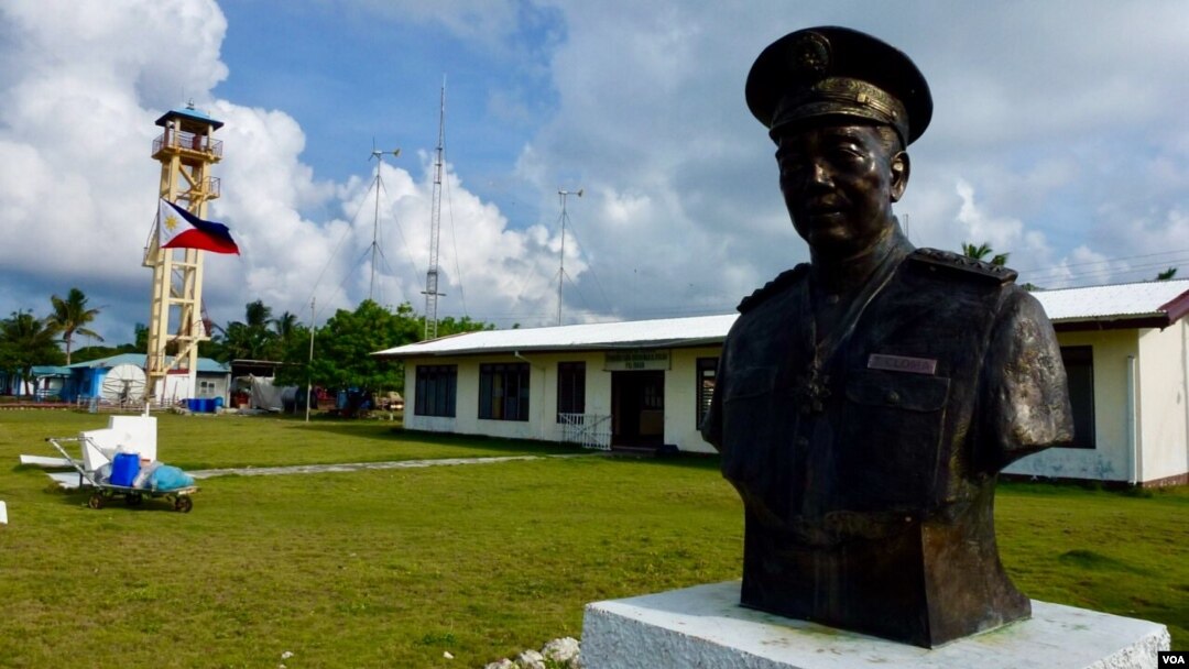 The main town hall of Kalayaan on Thitu Island with the bust of Tomas Cloma, the Filipino marine educator a nd entrepreneur who reportedly discovered the Kalayaan Group of Islands. The lone tower is also seen in the background. (D. Agnote for VOA)