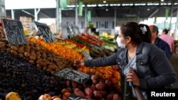 FOTO DE ARCHIVO: Una mujer que usa una mascarilla como medida preventiva contra el coronavirus (COVID-19) realiza compras en el Mercado Central del alimentos, en La Matanza, en las afueras de Buenos Aires, Argentina 1 de abril, 2020.