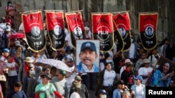 Los partidarios llevan pancartas del Frente Sandinista de Liberación Nacional (FSLN) y un retrato del presidente Daniel Ortega, mientras participan en una marcha progubernamental en Managua, Nicaragua, el 11 de febrero de 2023. REUTERS/Stringer