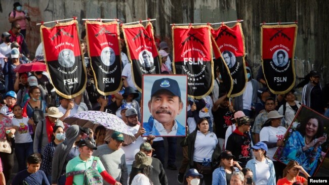 Los partidarios llevan pancartas del Frente Sandinista de Liberación Nacional (FSLN) y un retrato del presidente Daniel Ortega, mientras participan en una marcha progubernamental en Managua, Nicaragua, el 11 de febrero de 2023. REUTERS/Stringer