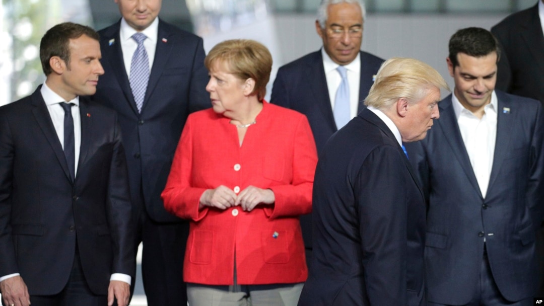 Arhiva - Francuski predsednik Emanuel Makron, levo, razgovara sa nemačkom kancelarkom Angelom Merkel, dok predsednik Donald Tramp zauzima svoje mesto pred grupno fotografisanje u novom sedištu NATO-a u Briselu, 25. maja 2017.