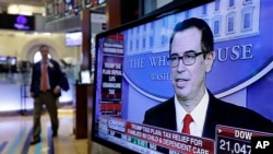 Treasury Secretary Steven Mnuchin appears on a television screen on the floor of the New York Stock Exchange, April 26, 2017. 