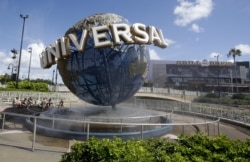 FILE - In this Thursday, Oct. 22, 2015, file photo, park guests relax at Universal Studios City Walk in Orlando, Fla.