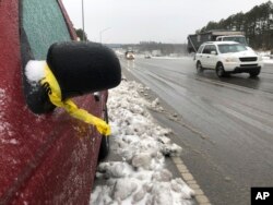 Una cinta de la policía cuelga del espejo de una camioneta pickup varada a lo largo de la autopista 1 en Raleigh, N.C., el lunes 10 de diciembre de 2018.