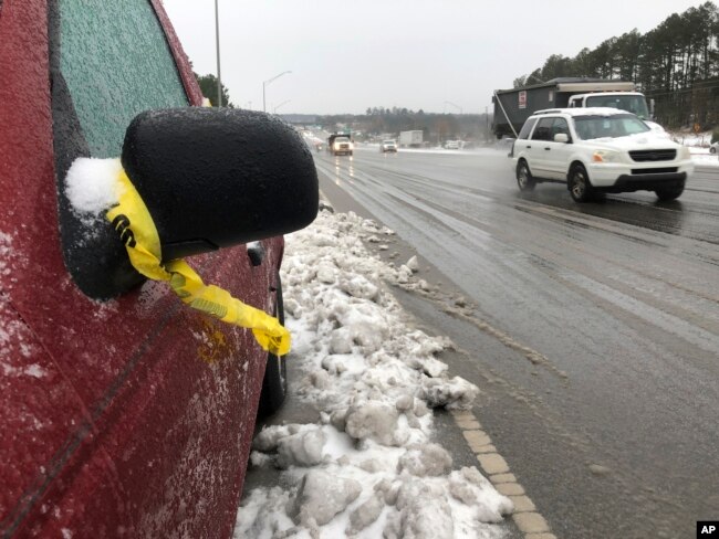 Una cinta de la policía cuelga del espejo de una camioneta pickup varada a lo largo de la autopista 1 en Raleigh, N.C., el lunes 10 de diciembre de 2018.