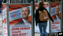 Seorang perempuan Austria melewati poster Norbert Hofer, Capres dari Partai Kebebasan – kelompok sayap kanan Austria yang anti-imigrasi, di Wina (19/4).