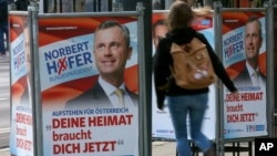 A woman walks past election posters of Norbert Hofer, candidate for presidential elections of Austria's right-wing Freedom Party, FPOe, in Vienna, Austria, April 19, 2016. The posters read "Your country needs you now."