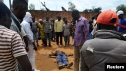 Civilians gather to look at the dead body of an unidentified man killed during fighting between the army and militia fighters in Beni, eastern Democratic Republic of the Congo, June 22, 2017.