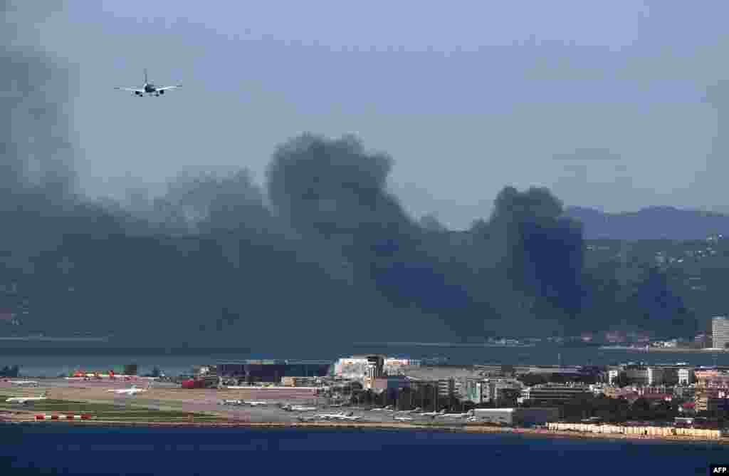 프랑스 니스 국제공항 인근 빌르뇌브루베에 있는 창고에 화재가 발생해 연기가 피어오르는 가운데 비행기가 착륙하고 있다. 