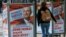 A woman walks past election posters of Norbert Hofer, candidate for presidential elections of Austria's right-wing Freedom Party, FPOe, in Vienna, Austria, April 19, 2016. The posters read "Your country needs you now."