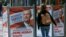 A woman walks past election posters of Norbert Hofer, candidate for presidential elections of Austria's right-wing Freedom Party, FPOE, in Vienna, Austria, April 19, 2016.