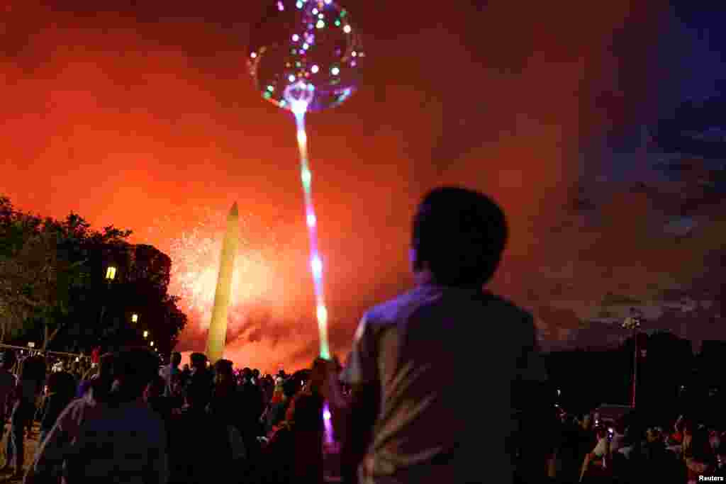 People enjoy the fireworks display during Independence Day celebrations at the National Mall in Washington, July 4, 2021.
