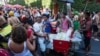 Revelers mill about as vendors with coolers filled with ice cold drinks wait for customers at the Heaven on Earth pre-Carnival street party, in Rio de Janeiro, Feb. 22, 2025.