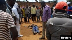 Civilians gather to look at the dead body of an unidentified man killed during fighting between the army and militia fighters in Beni, eastern Democratic Republic of the Congo, June 22, 2017.