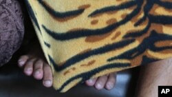 FILE - Suspects in an alleged Internet porn operation in the Philippines hide their faces after being taken into custody in Manila, Feb. 18, 2014. A new sting operation has netted 60 suspects in a porn ring spanning the United States and Latin America. 