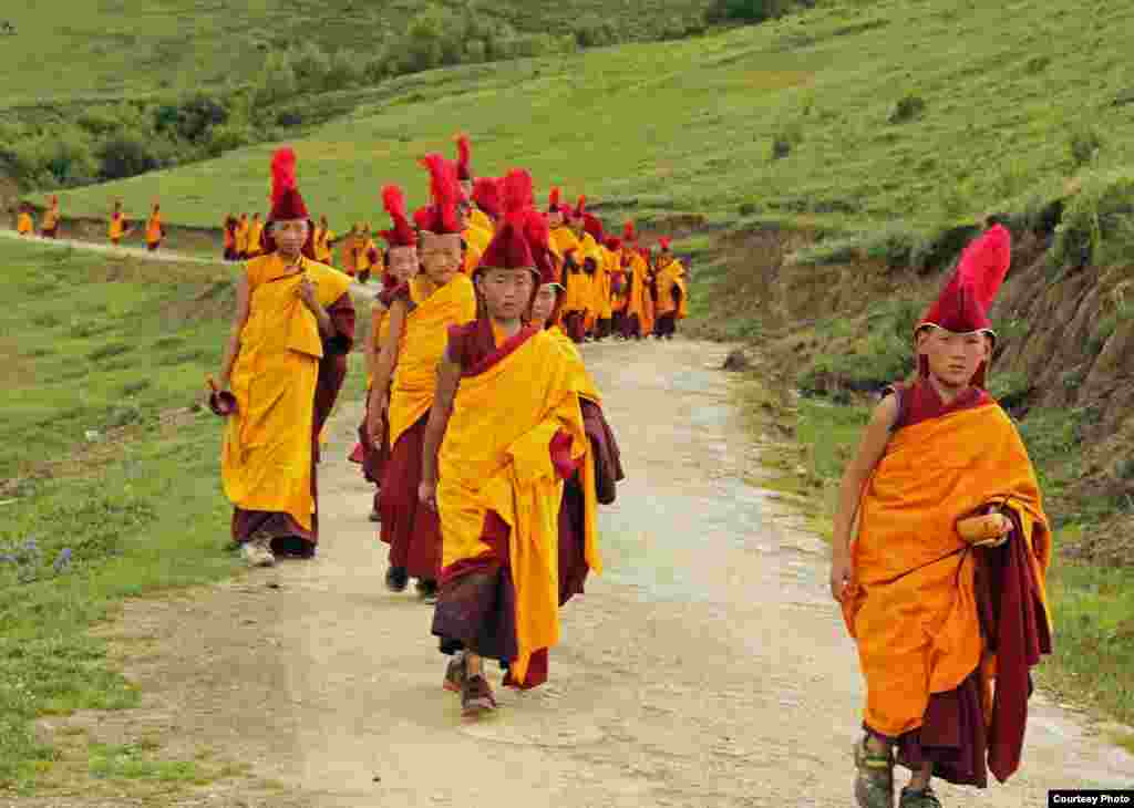 Para biarawan muda berjalan mengambil makanan di biara Changlie, prefektur Aba, provinsi Sichuan di Tiongkok, China. (Tongqi Huang/Tiongkok/pembaca VOA)