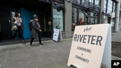 In this January 11, 2019, photo, women exit The Riveter, a women-centered shared workspace business in Seattle.
