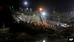 Rescuers work at the scene after a highway overpass collapsed on a sewage canal in Kolkata, India, Tuesday, Sept. 4, 2018. 