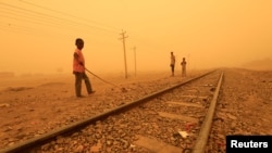 FILE - Children play near railways during a sandstorm in Khartoum, Sudan, March 29, 2018. 