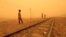 FILE - Children play near railways during a sandstorm in Khartoum, Sudan, March 29, 2018. 