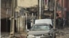 People gather at the site of a bomb explosion at a road in Kaduna, Nigeria on Sunday, April 8, 2012.