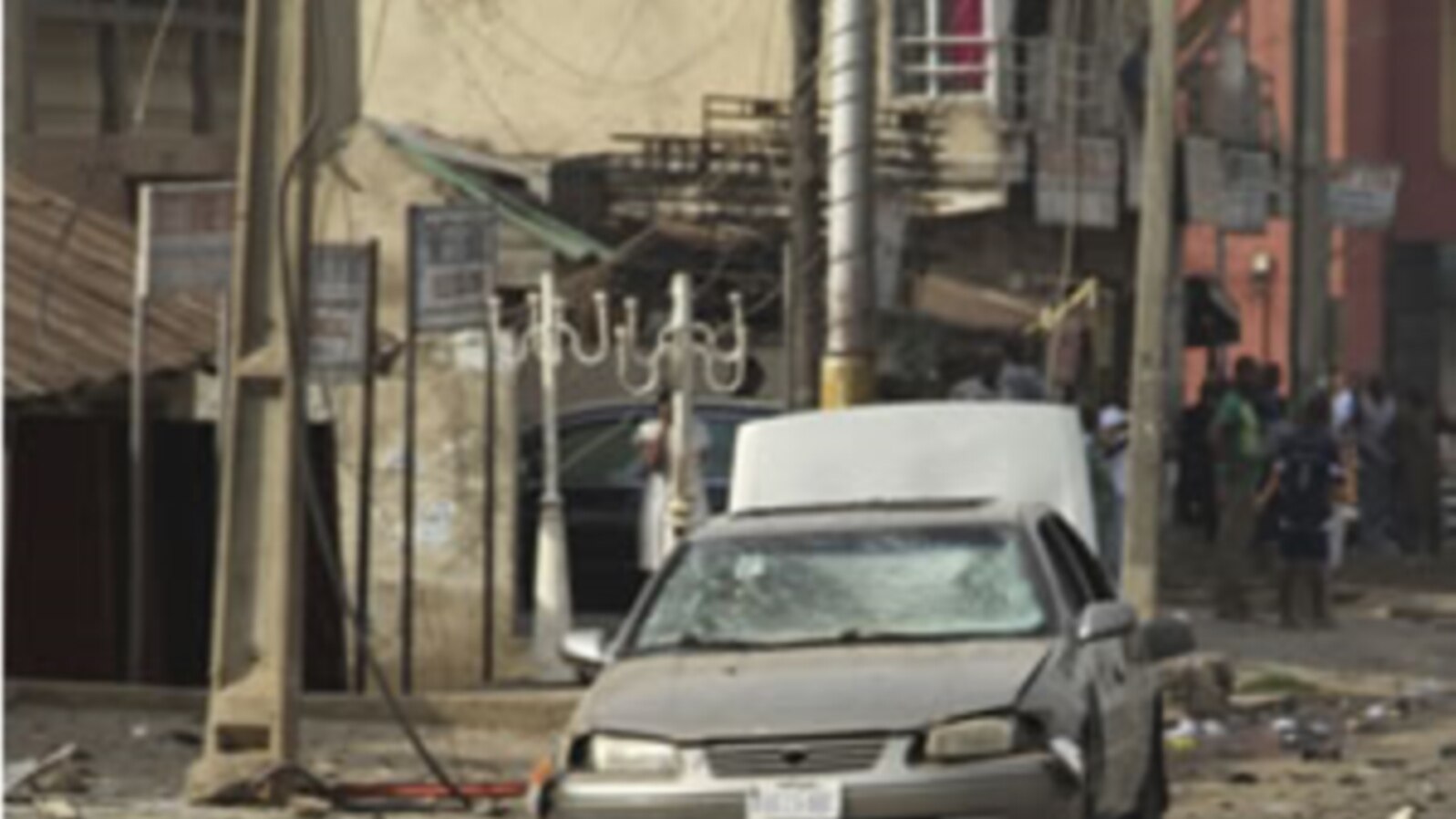 People gather at the site of a bomb explosion at a road in Kaduna, Nigeria on Sunday, April 8, 2012.