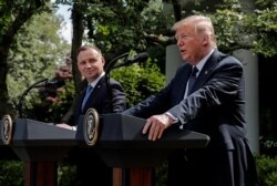FILE - Poland's President Andrzej Duda listens to U.S. President Donald Trump during a joint news conference in the Rose Garden at the White House in Washington, June 24, 2020.