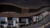 Trucks queue next to the border wall before crossing to the United States at Otay commercial port in Tijuana, Baja California state, Mexico, on Jan. 22, 2025. 