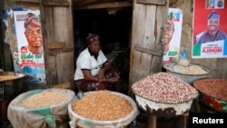 FILE - Latefat Alao, 56, a ethnic Yoruba Muslim woman, waits for customers in front of her in Beere market in Ibadan, southwest Nigeria, Jan. 29, 2015. 