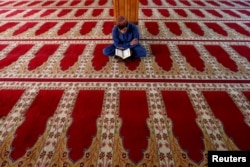An Afghan man reads the Quran at a mosque on the first day of the holy month of Ramadan in Kabul, Afghanistan, May 27, 2017.