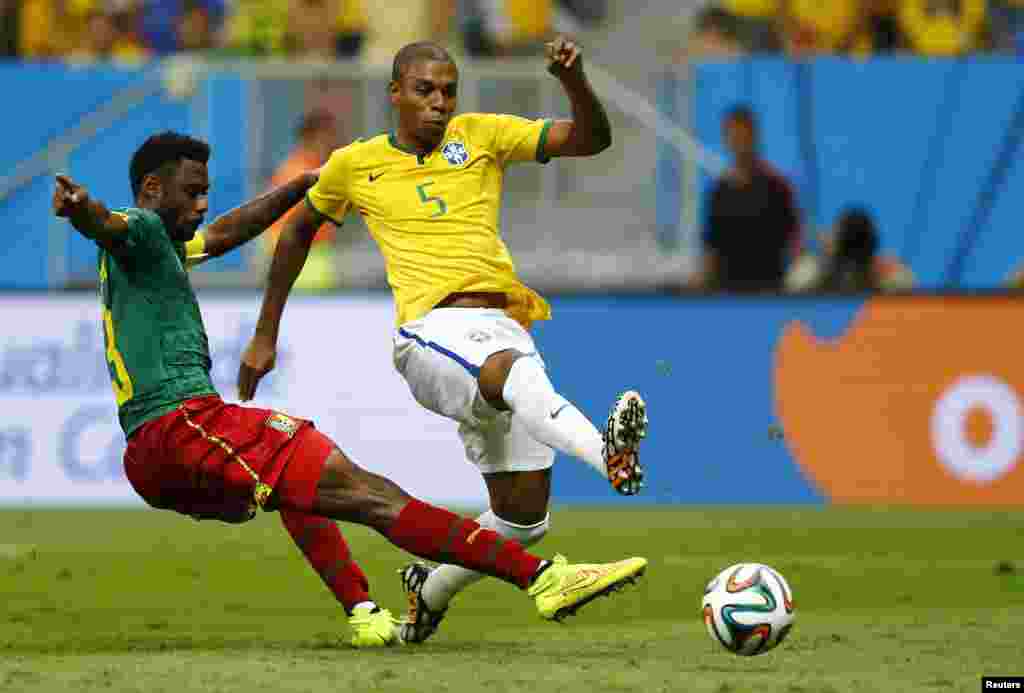 Brazil's Fernandinho (R) shoots to score past Cameroon's Nicolas Nkoulou during their 2014 World Cup Group A soccer match at the Brasilia national stadium in Brasilia, June 23, 2014. 