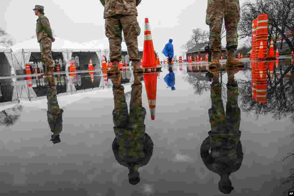 National Guard personnel stand at attention as they wait for patients to arrive for COVID-19 coronavirus testing facility at Glen Island Park, in New Rochelle, N.Y.