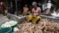 Une femme épluche des couches extérieures de manioc pour le plat d'accompagnement, attiéké, à Abidjan, le 22 mai 2018.